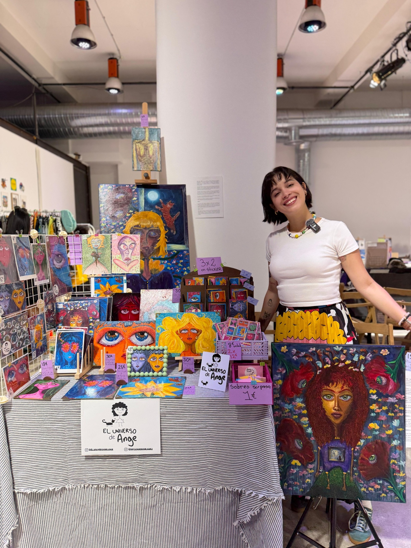 Ange en su stand con obras y prints